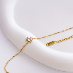 Macro detail of gold titanium steel chain bracelet with square crystal and K18 hallmark tag