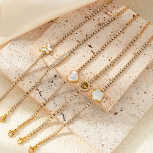 Detailed view of 5-piece gold bracelet set with butterfly and heart charms on stone