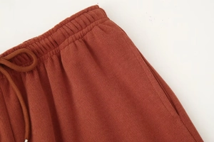 Detailansicht des elastischen Bundes mit Kordelzug an der ziegelroten Strickhose