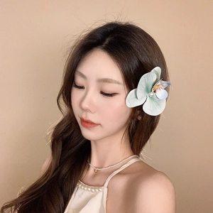 Detailed side view of floral pearl hair clip with soft green and blue gradient petals