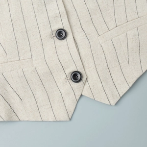 Detail of beige striped linen waistcoat featuring classic buttons and sharp pockets