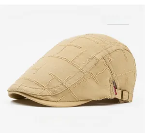 Detail view of khaki cotton beret with worn texture, grid stitching and metal buckle
