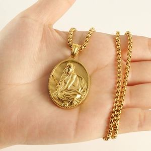 Pendentif portrait en or religieux avec chaîne box tenu dans la main