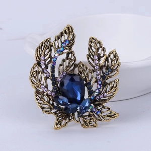 Elegant vintage gold flower brooch with blue teardrop gemstone and purple rhinestones