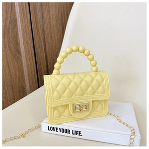 Detail of yellow PVC jelly bag with bead handle, chain strap and quilted texture