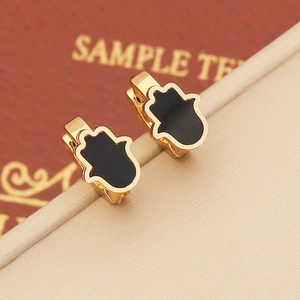 Detail of Hamsa Hand hoop earring in gold finish with black enamel dripping oil detail