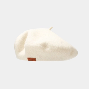 Close-up of wool felt beret with a brown leather logo tag and embossed lettering