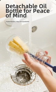 Detail of detachable glass oil dispenser being washed with a blue sponge brush