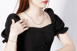 Silver chain jewelry set showing a necklace and bracelet worn on a model's neck and wrist
