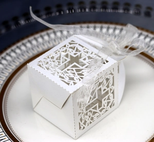 Detailed view of laser-cut cross patterns on white pearlescent wedding favor paper box