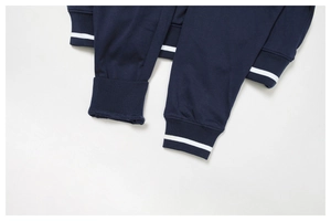 Macro detail of navy blue sweatshirt cuff featuring white contrast stripes and ribbed texture
