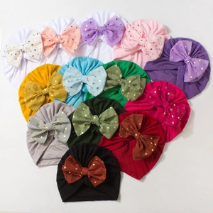 Infant turban hats with gold-dot bows in 13 various colors arranged in a heart shape