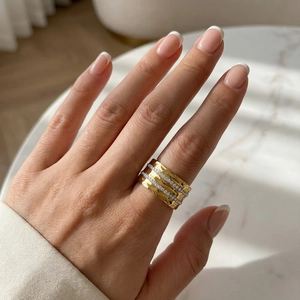 Detail of wide hammered gold band with double row pavé zircons on model hand