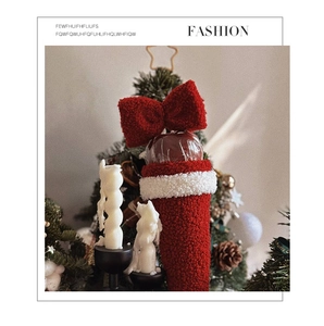 Close-up of red lamb wool Christmas apple gift bag with a large bow and white plush trim