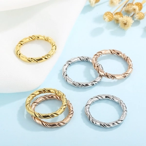 Flat lay of multiple twist braided rings in gold silver and rose gold metal finishes