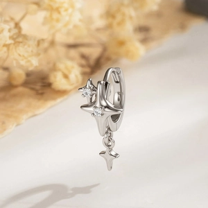 Silver star huggie hoop earrings with sparkling gems on a soft minimalist background