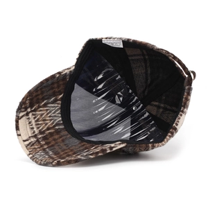 Detailed interior of plaid baseball cap showing 100% polyester fabric and washing label
