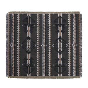 Detailed view of bohemian tribal pattern weaving with decorative tassels on camp blanket