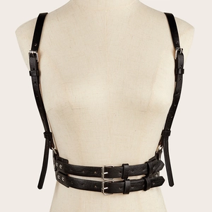 Detail of punk style black leather body harness with adjustable straps and metal buckles