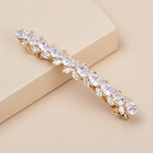 Detailed macro of golden leaf hairpin with sparkling rhinestones and crystal accents