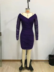 Dettaglio dell'abito in mesh glitterato viola con scollo a V scoperto e maniche lunghe