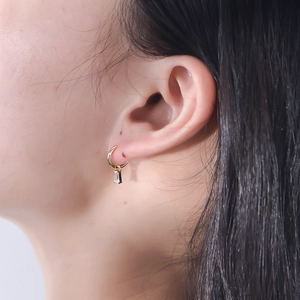 Close-up of geometric square zircon earrings in s925 silver on a female model