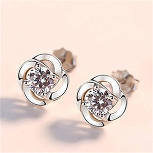 Macro detail of silver four-leaf clover stud earrings with sparkling cubic zirconia stones
