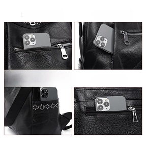 Dettaglio dello zaino in pelle nera con quattro tasche con cerniera e rivetti in argento