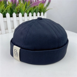 Detail of black cotton docker cap showing fabric texture and side textile brand label