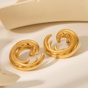 Elegant gold spiral C-shape earrings with a polished metallic finish in a studio setting