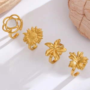 Detail of four gold floral open rings featuring sunflowers and white heart accents