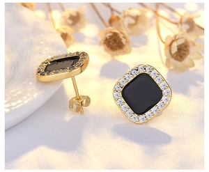 Detail of vintage French gold metal chain earrings with black inlay and zircons