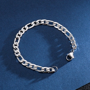 Polished silver Figaro link chain bracelet for men and women on deep blue background