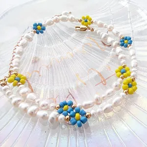 Detail of baroque freshwater pearl necklace with yellow and blue beaded floral charms