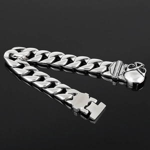 Men's stainless steel skull and shield curb chain bracelet on black reflective background