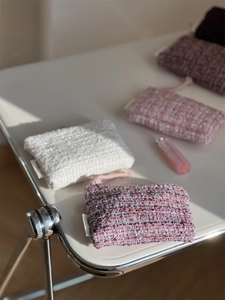 Detailed texture of tweed mini coin purses with elegant woven fibers and simple wish label