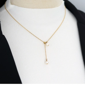 Detail of adjustable gold-plated titanium necklace with natural freshwater pearl tassels