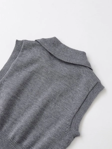 Macro detail of the grey knitted vest collar showing soft texture and ribbed edges