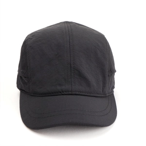 Detailed close-up of quick-dry black five-panel baseball cap with fine matte nylon texture