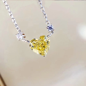 Elegant heart-shaped yellow gemstone necklace with side crystals and silver metal chain