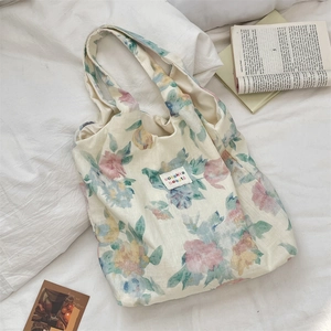 Close-up of floral linen tote bag with artistic flower print and brand logo label