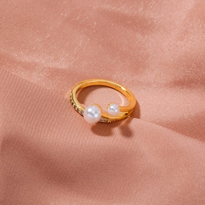 Detailed macro of golden adjustable ring featuring double pearls and sparkling rhinestones