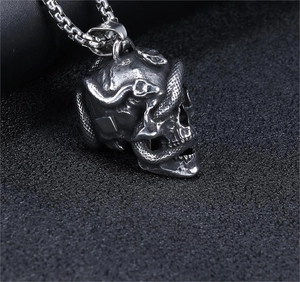 Macro shot of a vintage silver skull and snake pendant with detailed 3D carving