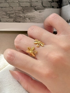Detailed view of adjustable gold daisy ring featuring two elegant flower charms on a hand