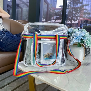 Transparente PVC-Reisetasche mit Regenbogengriffen zeigt Stauraum auf einem Tisch
