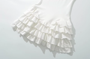 Detail showing white tiered ruffle hem on a sleeveless mini dress for women