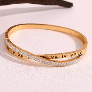 Macro shot of 18K gold plated cross bangle featuring pavé crystals and Roman numerals