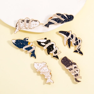 Detailed view of whale enamel pins with motivational quotes on decorative props