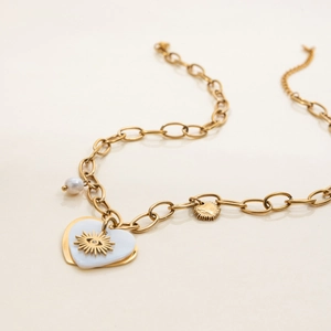 Gold stainless steel heart pendant necklace with sun eye motif and pearl detail