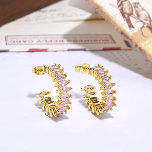 Macro shot of gold-plated C-shaped earrings with pink marquise-cut cubic zirconia